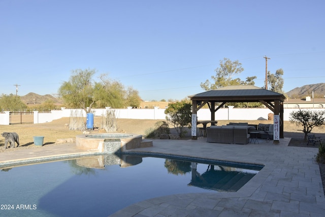 view of pool featuring a gazebo, an in ground hot tub, a mountain view, and an outdoor hangout area