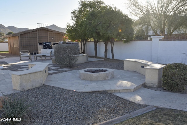 view of patio with a mountain view and an outdoor living space with a fire pit