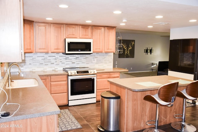 kitchen featuring backsplash, white electric range, sink, and light brown cabinetry