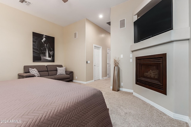 bedroom featuring a towering ceiling and light colored carpet