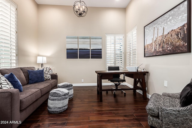 office with dark hardwood / wood-style flooring and an inviting chandelier