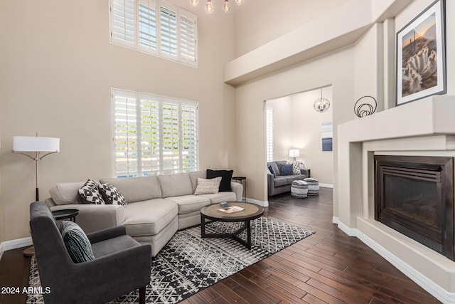 living room with dark wood-type flooring and a high ceiling