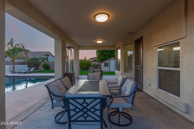 patio terrace at dusk featuring a fenced in pool