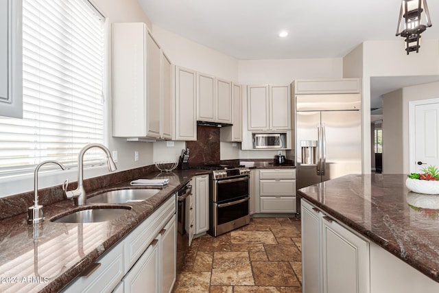 kitchen with stainless steel appliances, white cabinetry, and plenty of natural light