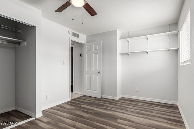 unfurnished bedroom featuring dark wood finished floors, baseboards, ceiling fan, and a closet