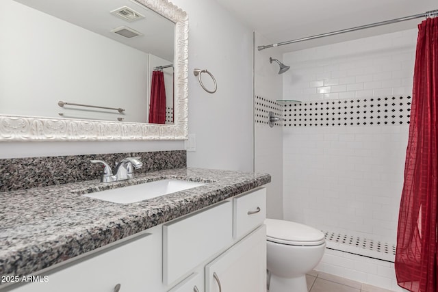 bathroom featuring tiled shower, vanity, toilet, and tile patterned floors