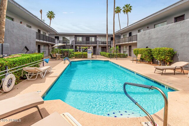 community pool featuring fence and a patio area
