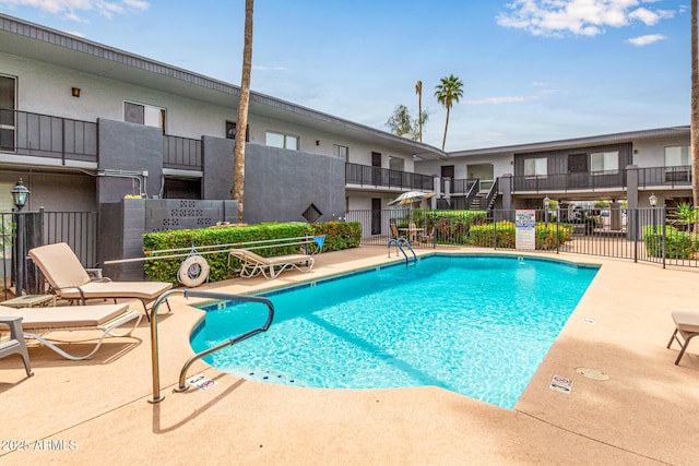 community pool featuring fence and a patio area