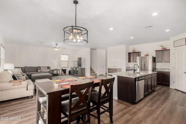 kitchen featuring appliances with stainless steel finishes, visible vents, dark brown cabinetry, and dark wood-style floors