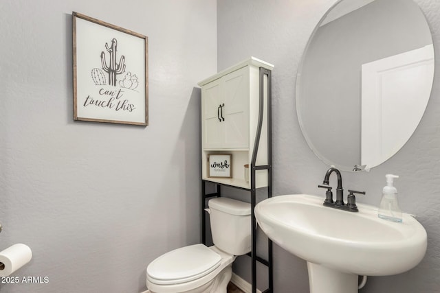 half bath featuring a sink and toilet