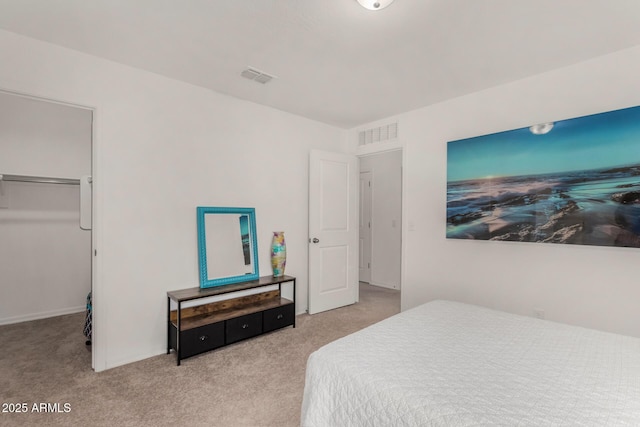 carpeted bedroom with a walk in closet and visible vents