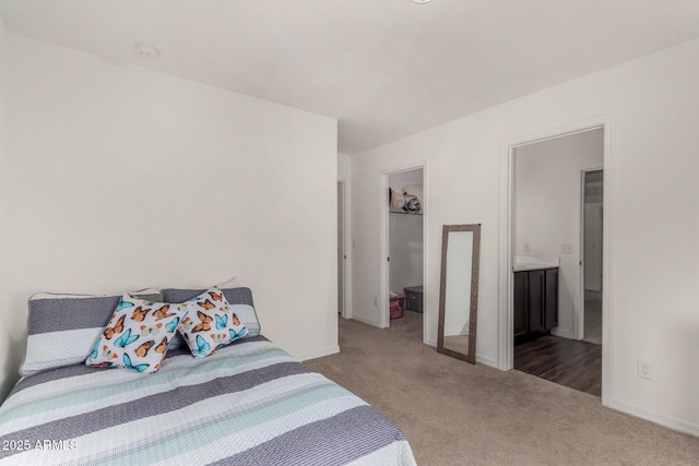 carpeted bedroom featuring a closet, a walk in closet, and baseboards