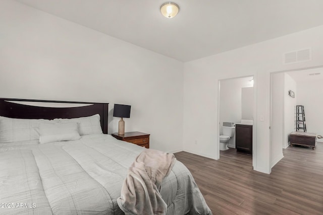 bedroom featuring ensuite bathroom, wood finished floors, visible vents, and baseboards