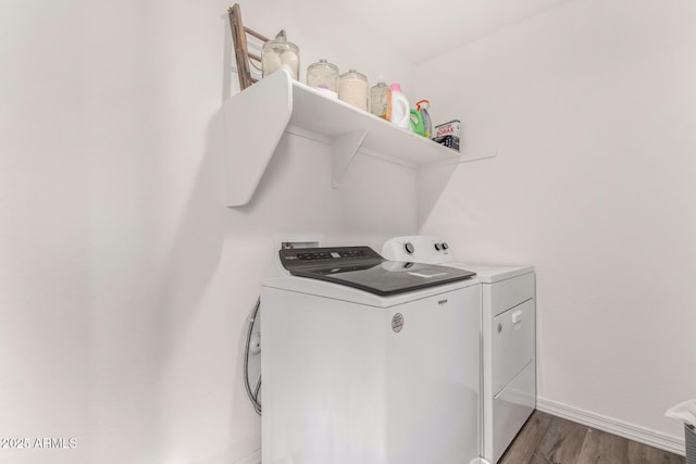 washroom featuring dark wood-type flooring, laundry area, washer and clothes dryer, and baseboards