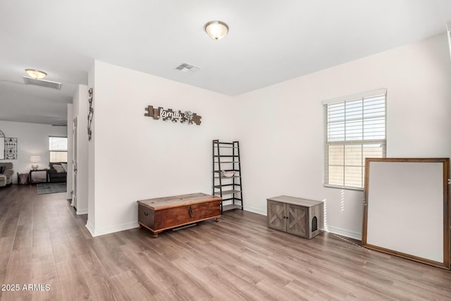 interior space featuring light wood-style floors, visible vents, and baseboards