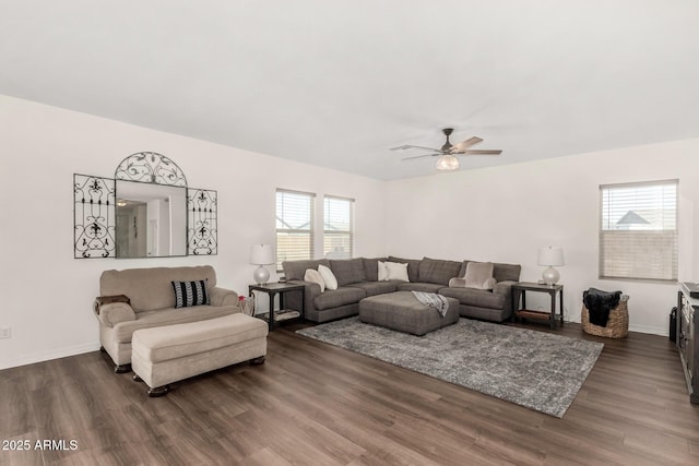 living area with dark wood-style floors, baseboards, a ceiling fan, and a wealth of natural light