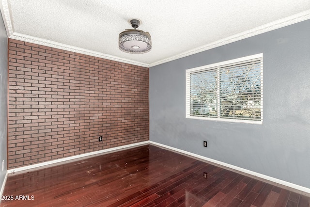 3135 W Echo Ln, Phoenix, AZ 85051 - empty room featuring hardwood / wood-style flooring, ornamental molding, a textured ceiling, and brick wall