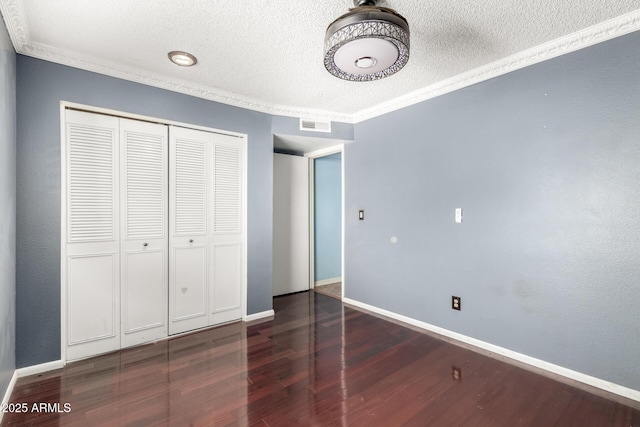 3135 W Echo Ln, Phoenix, AZ 85051 - unfurnished bedroom with dark wood-type flooring, ornamental molding, a closet, and a textured ceiling