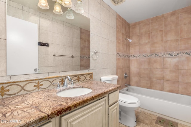 3135 W Echo Ln, Phoenix, AZ 85051 - full bathroom featuring tile patterned floors, toilet, tile walls, vanity, and tiled shower / bath combo