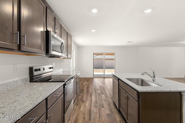 4051 N Ghost Hollow Way, Casa Grande, AZ 85122 - kitchen with appliances with stainless steel finishes, wood finished floors, dark brown cabinets, and a sink