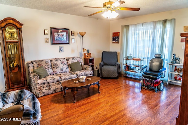 living area featuring ceiling fan, a textured ceiling, and wood finished floors