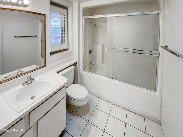 full bathroom featuring tile patterned flooring, vanity, bath / shower combo with glass door, and toilet