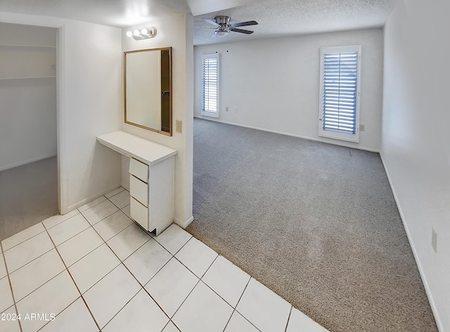 bathroom with ceiling fan and a textured ceiling