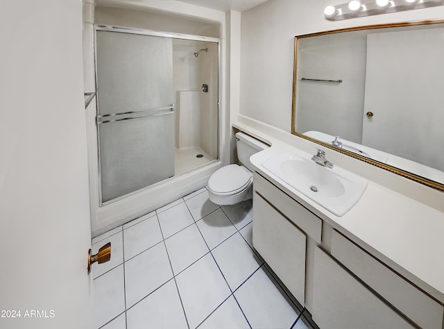 bathroom with tile patterned flooring, vanity, a shower with door, and toilet