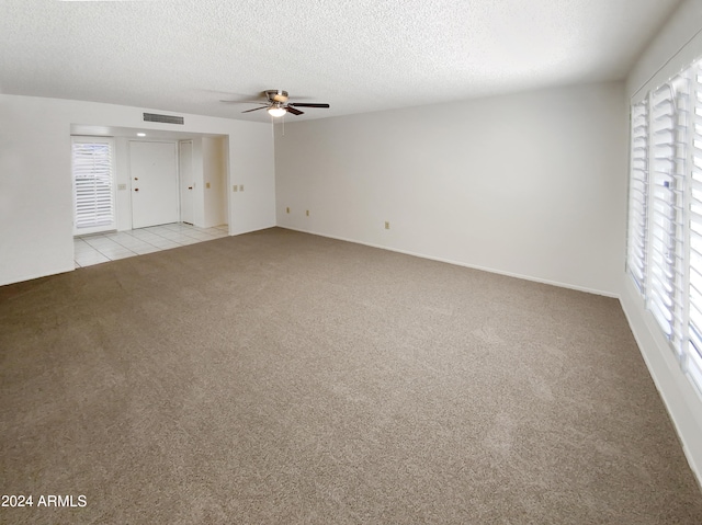 interior space with light carpet, a textured ceiling, and ceiling fan