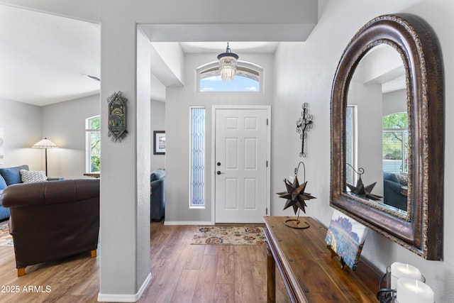 10333 E Gold Nugget Ct, Gold Canyon, AZ 85118 - entrance foyer featuring a chandelier, wood finished floors, baseboards, and arched walkways
