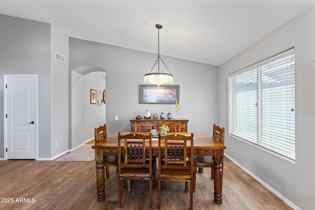 10333 E Gold Nugget Ct, Gold Canyon, AZ 85118 - dining area featuring arched walkways, vaulted ceiling, light wood finished floors, and baseboards