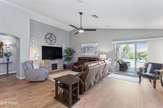 10333 E Gold Nugget Ct, Gold Canyon, AZ 85118 - living room featuring arched walkways, light wood-style floors, ceiling fan, high vaulted ceiling, and baseboards
