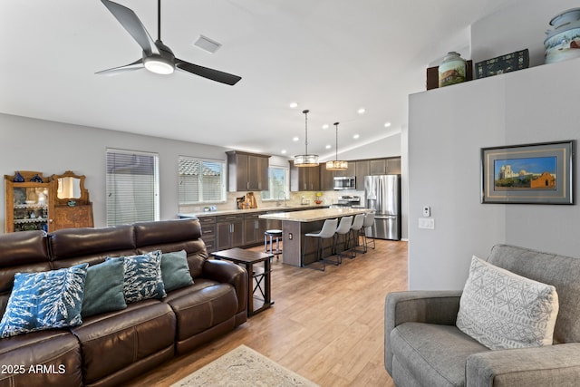 10333 E Gold Nugget Ct, Gold Canyon, AZ 85118 - living room with light wood-style flooring, lofted ceiling, a ceiling fan, and recessed lighting