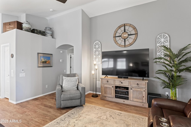 10333 E Gold Nugget Ct, Gold Canyon, AZ 85118 - living room featuring arched walkways, light wood-type flooring, baseboards, a ceiling fan, and a towering ceiling