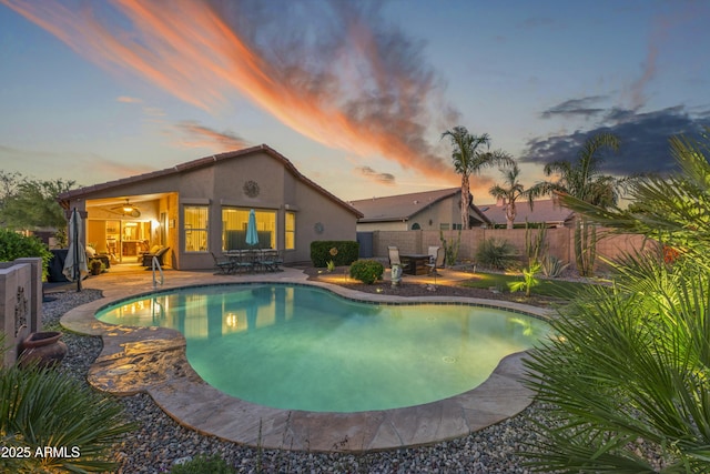 10333 E Gold Nugget Ct, Gold Canyon, AZ 85118 - pool at dusk with a patio area, a fenced backyard, and outdoor dining area