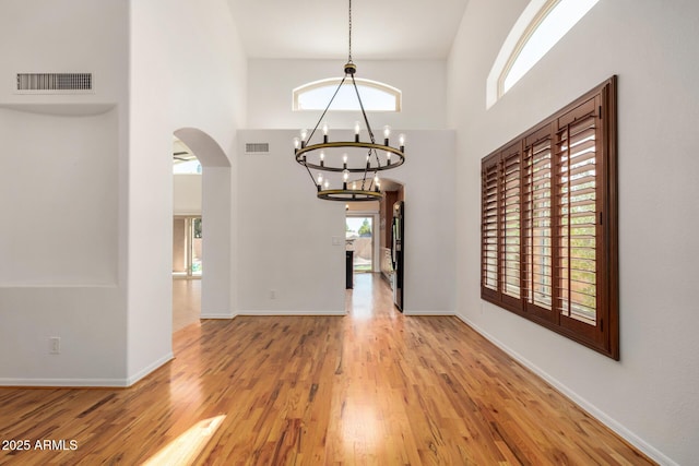 2226 N Gentry, Mesa, AZ 85213 - foyer featuring arched walkways, a chandelier, plenty of natural light, wood finished floors, and a high ceiling