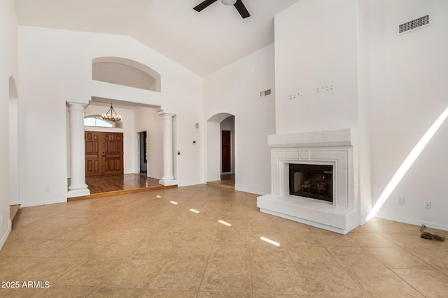 2226 N Gentry, Mesa, AZ 85213 - unfurnished living room featuring a ceiling fan, arched walkways, high vaulted ceiling, a fireplace with raised hearth, and decorative columns