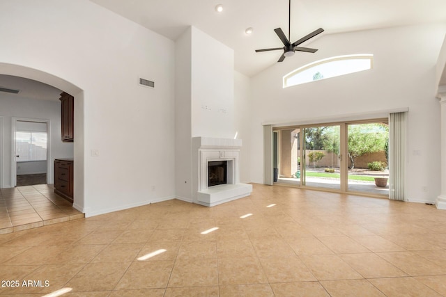 2226 N Gentry, Mesa, AZ 85213 - unfurnished living room with a ceiling fan, light tile patterned floors, high vaulted ceiling, a fireplace with raised hearth, and arched walkways