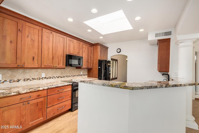 2226 N Gentry, Mesa, AZ 85213 - kitchen with black appliances, a skylight, stone countertops, recessed lighting, and brown cabinets