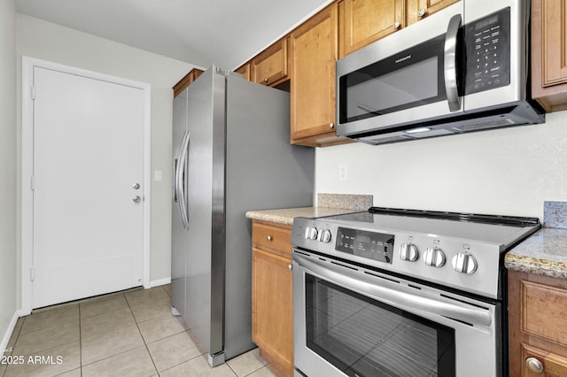 1811 S 39th St Unit 30, Mesa, AZ 85206 - kitchen with appliances with stainless steel finishes, brown cabinets, light tile patterned flooring, and baseboards