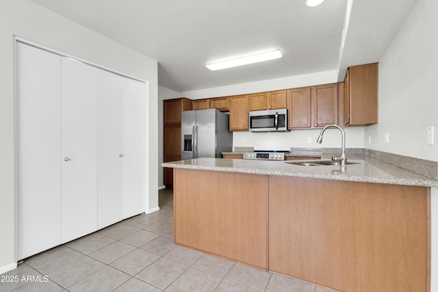 1811 S 39th St Unit 30, Mesa, AZ 85206 - kitchen featuring stainless steel appliances, a sink, a peninsula, light stone countertops, and light tile patterned floors