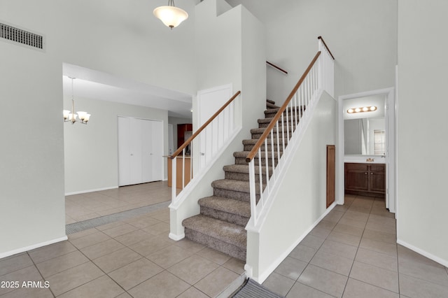 1811 S 39th St Unit 30, Mesa, AZ 85206 - stairway with a towering ceiling, tile patterned flooring, a chandelier, and baseboards