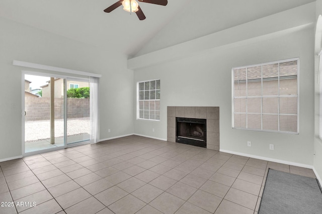 1811 S 39th St Unit 30, Mesa, AZ 85206 - unfurnished living room featuring tile patterned flooring, ceiling fan, a tiled fireplace, high vaulted ceiling, and baseboards