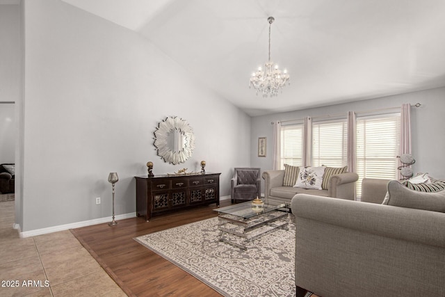 living room with a chandelier, hardwood / wood-style flooring, and vaulted ceiling