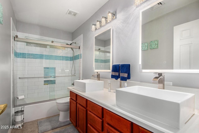 full bathroom featuring tile patterned flooring, toilet, combined bath / shower with glass door, and vanity