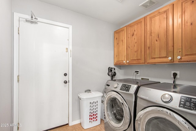 laundry area with cabinets, independent washer and dryer, and light tile patterned floors