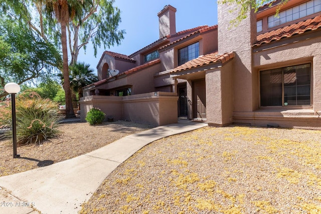609 E Mesquite Cir Unit D133, Tempe, AZ 85288 - mediterranean / spanish-style house with a chimney, stucco siding, a tile roof, and a gate