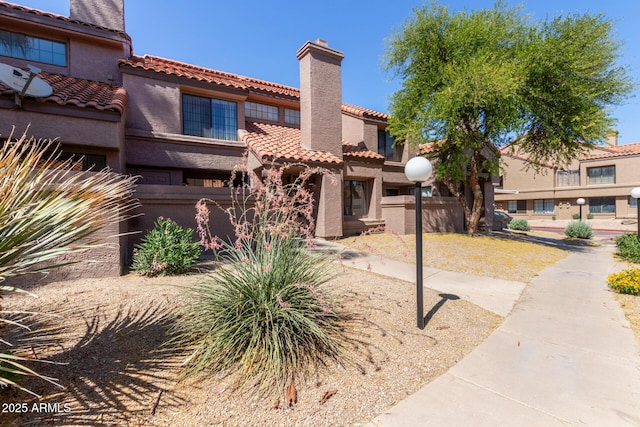 609 E Mesquite Cir Unit D133, Tempe, AZ 85288 - view of front of property featuring a chimney, a tile roof, and stucco siding