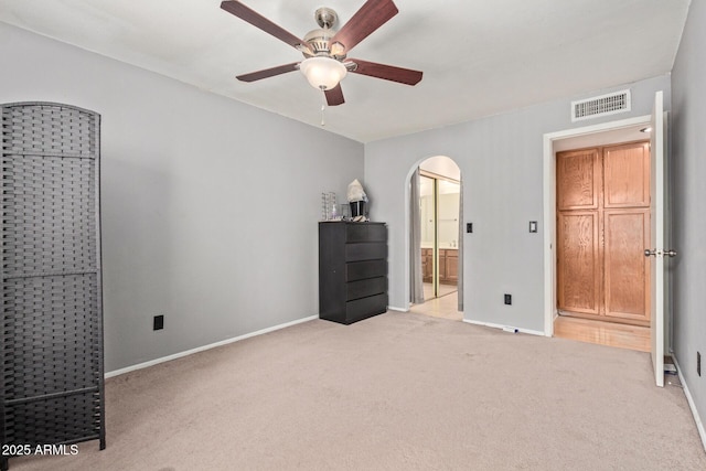 609 E Mesquite Cir Unit D133, Tempe, AZ 85288 - unfurnished bedroom featuring arched walkways, light colored carpet, ensuite bathroom, and a ceiling fan