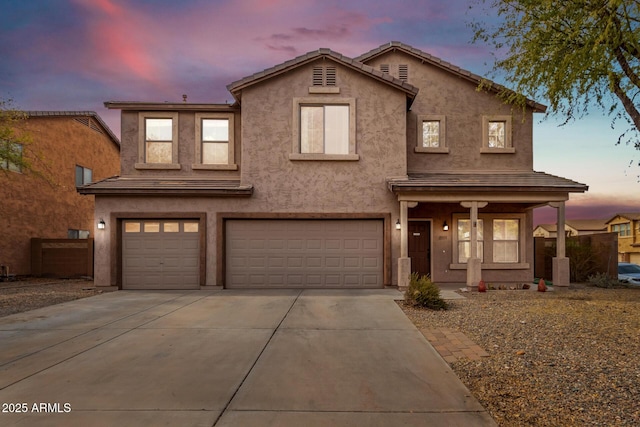 traditional-style house featuring stucco siding, covered porch, concrete driveway, and an attached garage